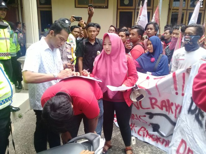 
Anggota DPRD Bangkalan Mahmudi saat tanda tangan surat pernyataan dihadapan Ketua Cabang GMNI Bangkalan Fitriana