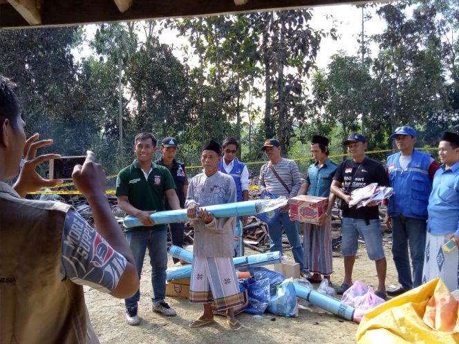 
Tim relawan Tagana Sampang Saat Memberikan Bantuan Berupa Sembako dan Alat-alat Rumah Kepada P Asmawi di Desa Gunung Kesan Kecamatan Karang Penang