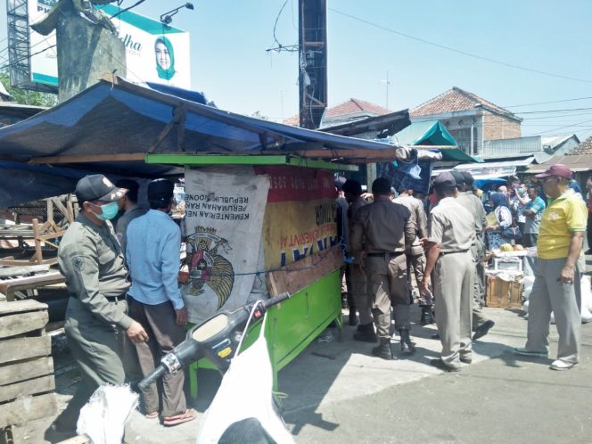
Satpol PP dibantu Masyarakat menata ulang lapak pedagang pasar buah di Pasar Blega demi mengurai kemacetan.