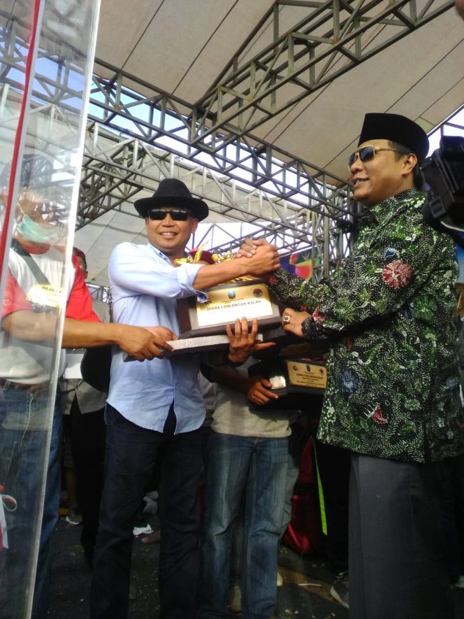 
Safiudin Asmoro pemilik pasangan sapi Setan Balap Junior menerima hadiah yang diserah oleh Moh Nizar Anggota DPR RI.
