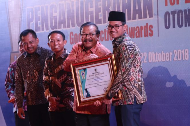 
Bupati Ra Latif menerima piagam penghargaan top 25 inovasi pelayanan publik yang diserahkan Gubernur jawa Timur.